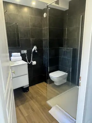 a bathroom with a toilet and a glass shower at Appartements PORTICCIO CENTRE in Porticcio
