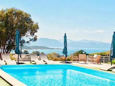 a swimming pool with chairs and umbrellas at Casa Nova Maison d'hôtes in Sagone