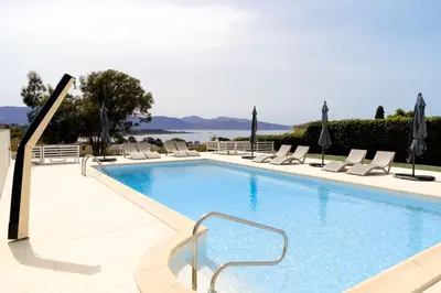 a swimming pool with lounge chairs and the water at Casa Nova Maison d'hôtes in Sagone
