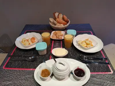 a table with plates of food and drinks and bread at Chambre d'hôtes couvent d'Alando in Alando