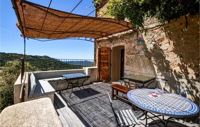 a patio with a table and chairs on a balcony at Awesome Home In Ville-Di-Paraso in Ville-di-Paraso