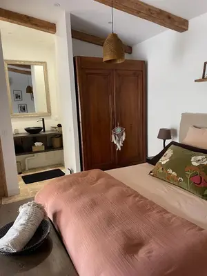 a bedroom with a bed and a table with a lamp at A Vadina Suite et chambres de charme Porticcio in Porticcio