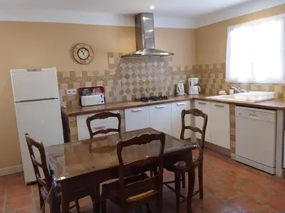 a kitchen with a table and chairs and a refrigerator at Casa Murtetu 3 étoiles in Porto-Vecchio