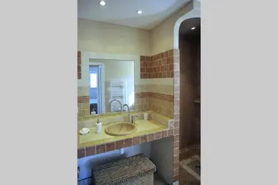 a bathroom with a sink and a mirror at Casa Murtetu 3 étoiles in Porto-Vecchio