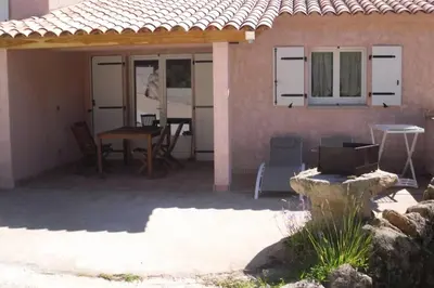a patio of a house with a table and chairs at Casa Murtetu 3 étoiles in Porto-Vecchio