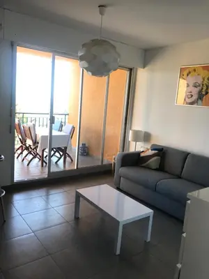a living room with a couch and a table at T2 route des sanguinaires vue mer panoramique in Ajaccio
