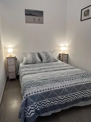a bed in a bedroom with two lamps on tables at T2 route des sanguinaires vue mer panoramique in Ajaccio