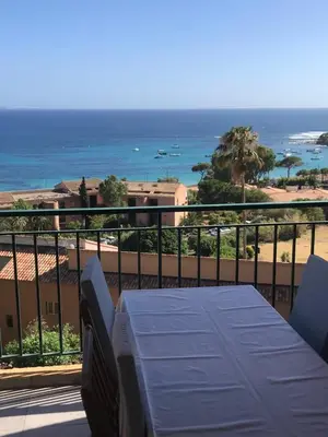 a balcony with a table and a view of the ocean at T2 route des sanguinaires vue mer panoramique in Ajaccio