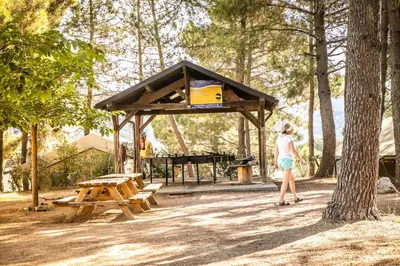 a woman standing in front of a picnic shelter at Camping Olva - Maeva in Sartène