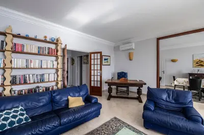 a living room with a blue couch and a book shelf at Appartement Front de Mer Hyper Centre in Ajaccio