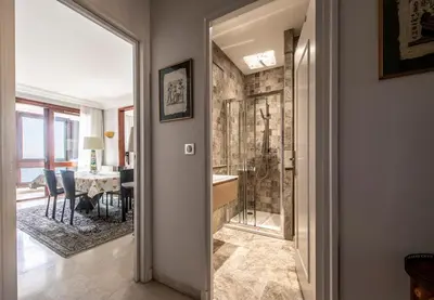 a bathroom with a shower and a dining room at Appartement Front de Mer Hyper Centre in Ajaccio