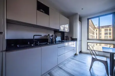 a kitchen with a sink and a table and a window at Appartement Front de Mer Hyper Centre in Ajaccio