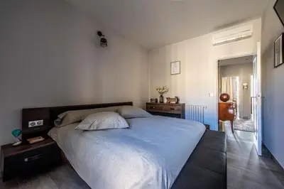 a bedroom with a large bed with a blue blanket at Appartement Front de Mer Hyper Centre in Ajaccio