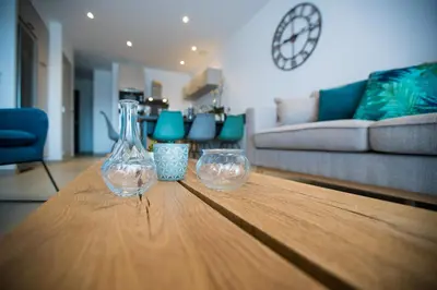 two wine glasses sitting on a wooden table in a living room at Résidence Saint Cyprien plage in Porto-Vecchio