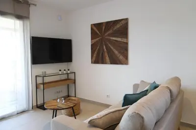 a living room with a couch and a tv at Résidence Saint Cyprien plage in Porto-Vecchio