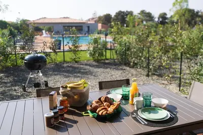 a table with food on it with a view of a pool at Résidence Saint Cyprien plage in Porto-Vecchio