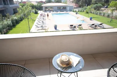 a hat sitting on a table on a balcony with a pool at Résidence Saint Cyprien plage in Porto-Vecchio
