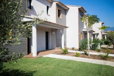 a house with a lawn in front of it at Résidence Saint Cyprien plage in Porto-Vecchio