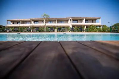a building with a swimming pool in front of it at Résidence Saint Cyprien plage in Porto-Vecchio