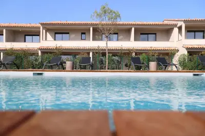a hotel with a swimming pool in front of a building at Résidence Saint Cyprien plage in Porto-Vecchio