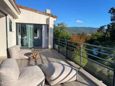 a deck with a couch and chairs on a balcony at Villa Macalia in Pietrosella