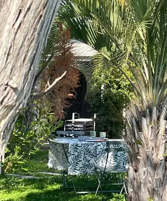 a blue and white table in a garden with palm trees at Villa Macalia in Pietrosella