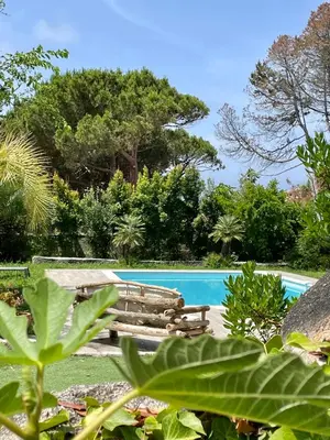 a swimming pool in a garden with trees at Villa Macalia in Pietrosella