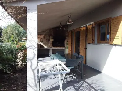 a patio with a table and chairs on a porch at casa-lesia in Porto-Vecchio