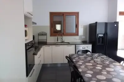 a kitchen with a table and a black refrigerator at casa-lesia in Porto-Vecchio