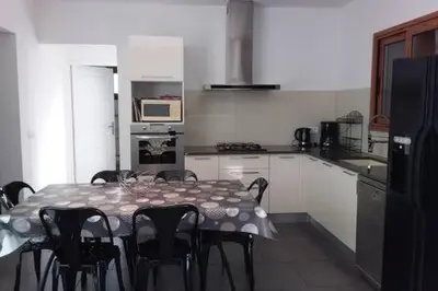 a kitchen with a table and chairs in a kitchen at casa-lesia in Porto-Vecchio