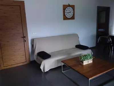 a living room with a couch and a clock on the wall at casa-lesia in Porto-Vecchio