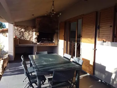 a patio with a table and chairs on a porch at casa-lesia in Porto-Vecchio