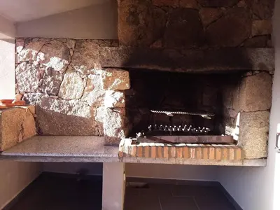 a stone fireplace in a room with a stone wall at casa-lesia in Porto-Vecchio