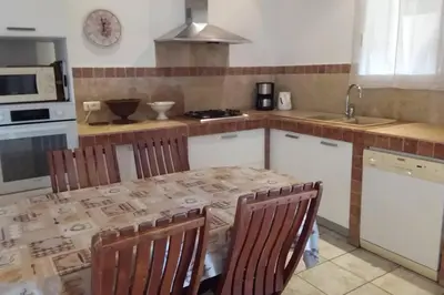 a kitchen with a table with chairs and a sink at casa-anghjulina in Porto-Vecchio