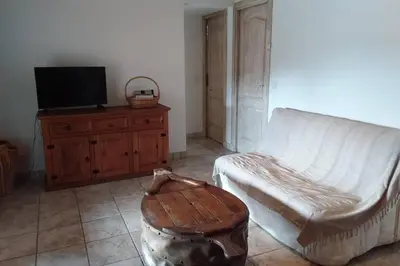 a living room with a couch and a tv and a stool at casa-anghjulina in Porto-Vecchio