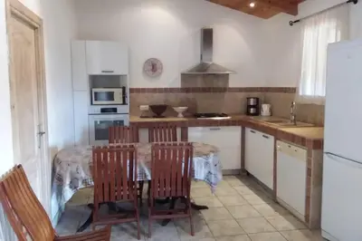 a kitchen with a table and some chairs in a room at casa-anghjulina in Porto-Vecchio