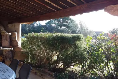 a patio with a table and chairs and trees at casa-anghjulina in Porto-Vecchio