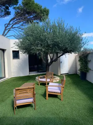 three chairs and a table and a tree in a yard at Villa Laricio in Bonifacio