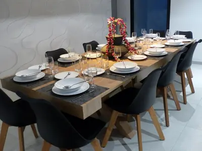 a long wooden table with chairs and plates and wine glasses at Villa Laricio in Bonifacio
