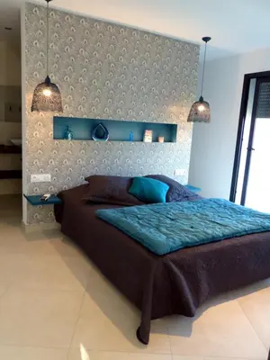 a bedroom with a large bed and two lights at Villa Laricio in Bonifacio