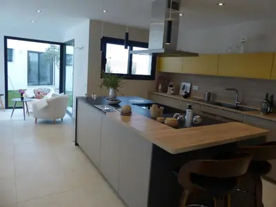 a kitchen with a counter with a sink and some chairs at Villa Laricio in Bonifacio