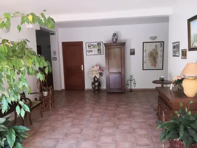 a living room with a tile floor and two doors at l'Ogliastru in Ucciani