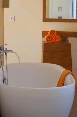 a white bath tub in a room with a mirror at Fiore di Machja in Coti-Chiavari