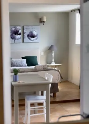 a white bedroom with a bed and a table at Fiore di Machja in Coti-Chiavari