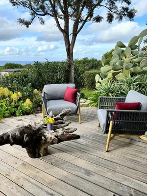 a patio with two chairs and a tree stump at Fiore di Machja in Coti-Chiavari