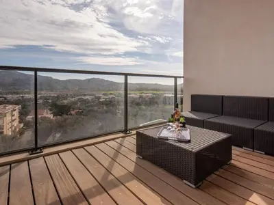 a balcony with a couch and a table on a deck at Apartment Château-19 by Interhome in Porto-Vecchio