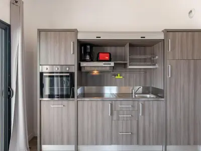 a kitchen with stainless steel cabinets and a sink at Apartment Château-19 by Interhome in Porto-Vecchio