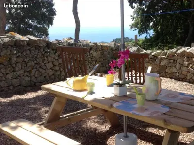 a wooden picnic table with flowers on top of it at Paomia in Cargèse