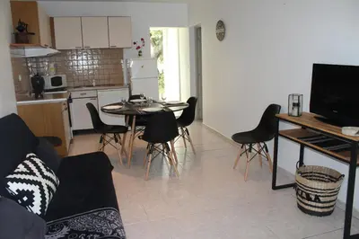 a kitchen and living room with a table and chairs at Paomia in Cargèse