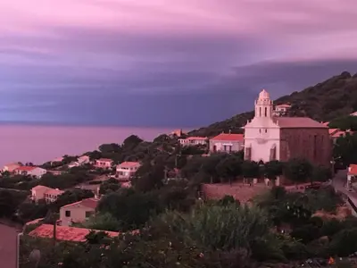 a view of a town with a church on a hill at Paomia in Cargèse